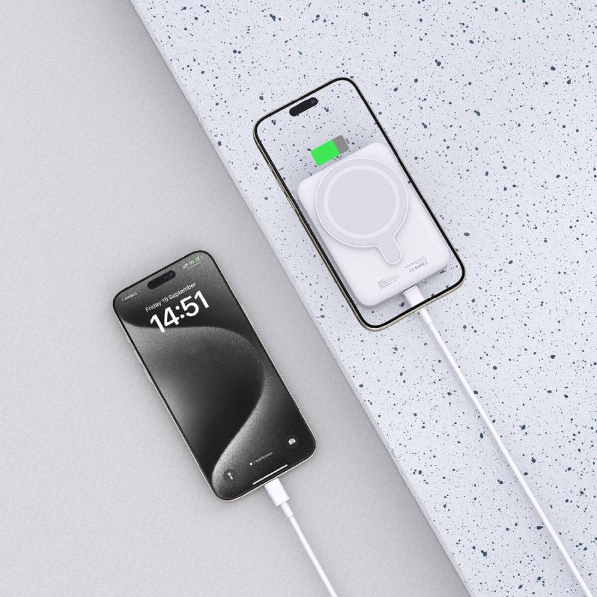 Zwei Smartphones laden drahtlos auf einer gesprenkelten Oberfläche. Das linke Telefon zeigt eine Uhrzeit von „14:51