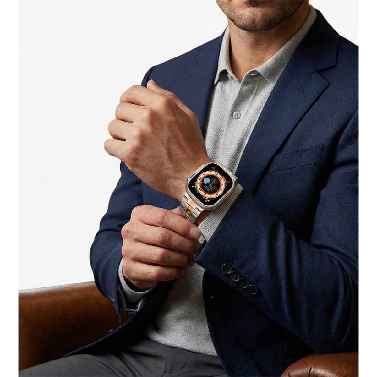 Eine Person trägt eine intelligente Uhr mit detailliertem Display, gekleidet in ein dunkelbllaues Sakko und sitzt, was auf eine moderne und stilvolle Umgebung hinweist.