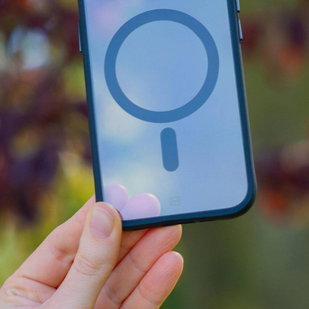 Nahaufnahme einer Hand, die ein Telefon hält, mit einem Lupe-Symbol auf dem Bildschirm, das Such- oder Zoom-Funktionalität symbolisiert.