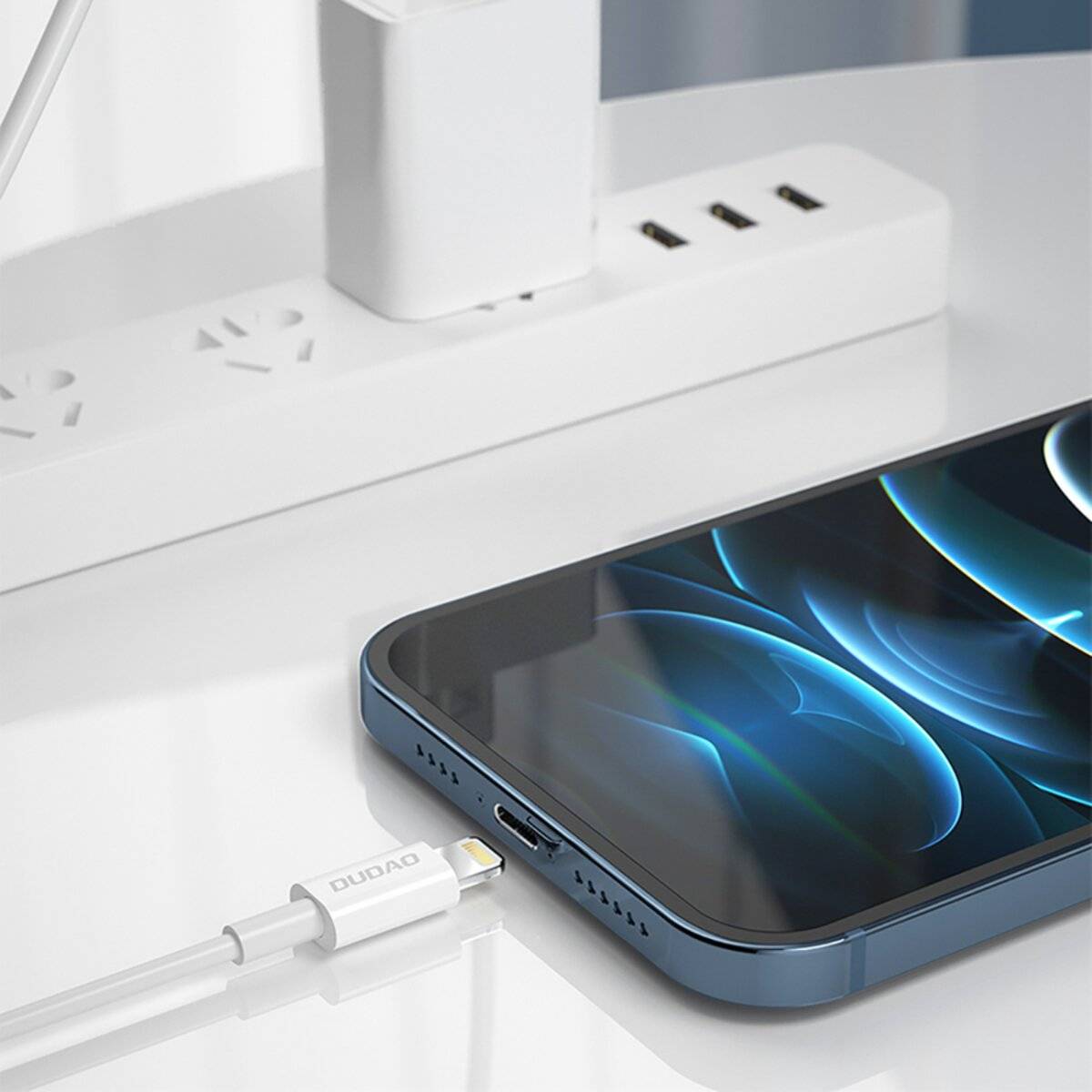 Ein Smartphone mit einem leuchtenden Bildschirm liegt neben einer weißen Steckdosenleiste mit mehreren Anschlüssen. Ein Ladekabel ist eingesteckt.