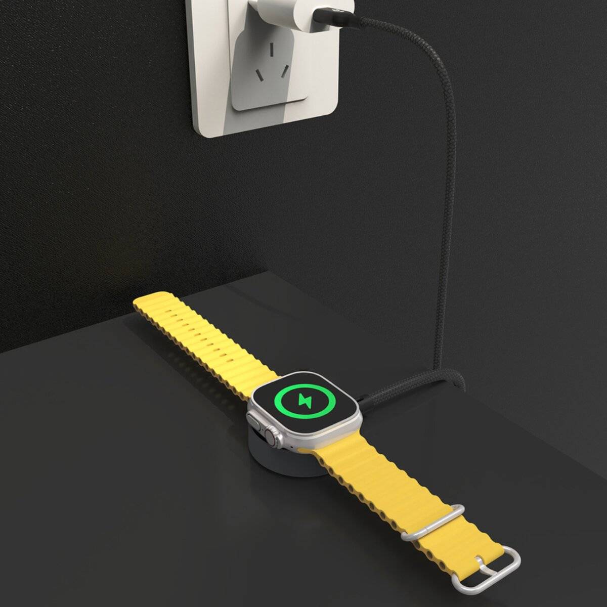 Eine Smartwatch mit einem gelben Armband lädt kabellos auf einer schwarzen Oberfläche neben einer Wandsteckdose, an der ein Ladekabel für ein Telefon angeschlossen ist.