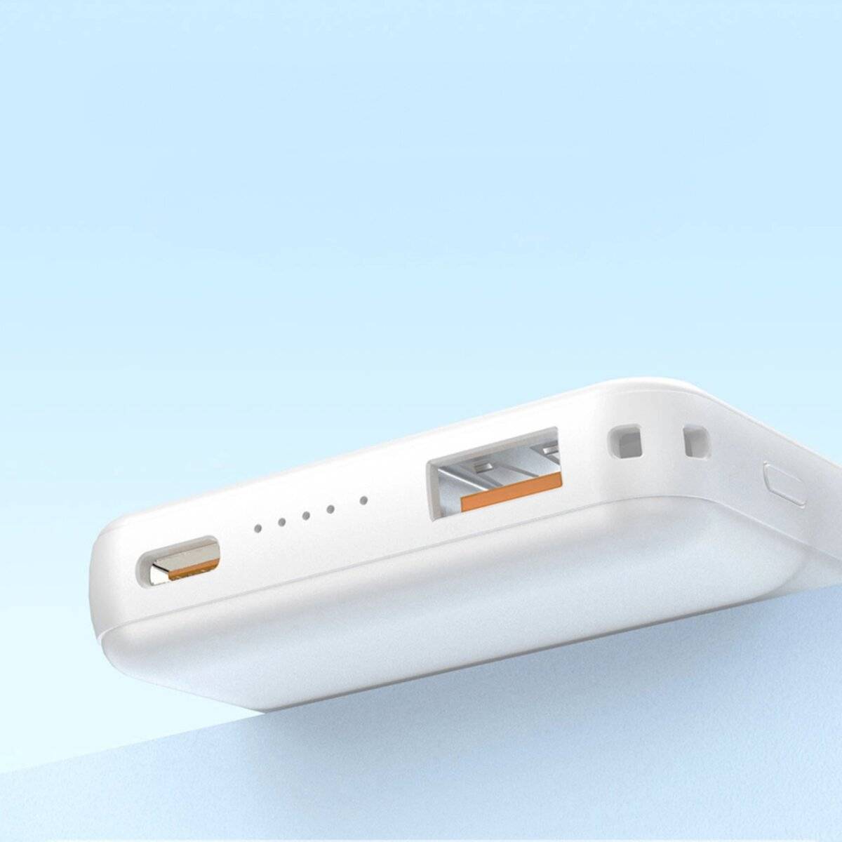 Eine weiße Powerbank mit einem USB-Anschluss, einem Ladeanschluss und LED-Anzeigen vor einem hellblauen Hintergrund.