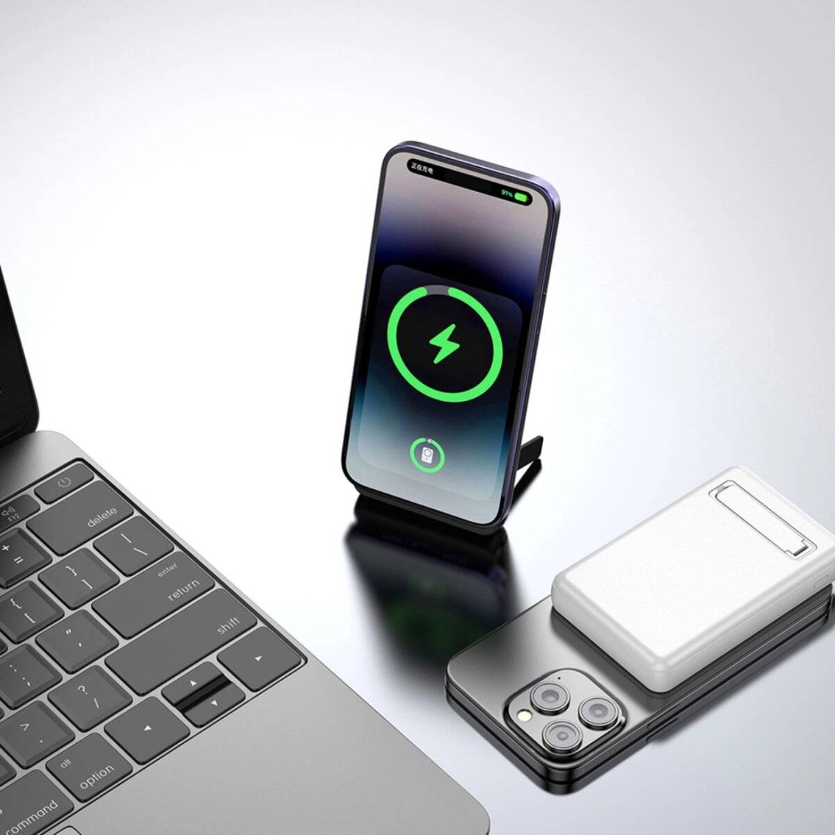Ein Smartphone, das drahtlos auf einem Ständer neben einem geschlossenen Laptop und einem flach liegenden Smartphone auflädt und damit eine technische Einrichtung zeigt.