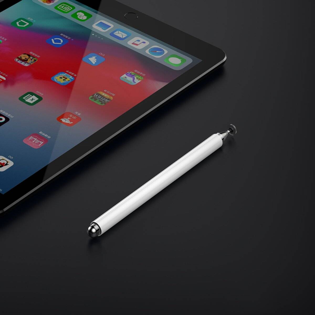 Eine schwarze Tablette mit bunten App-Symbolen auf dem Bildschirm wird schräg auf einer dunklen Oberfläche präsentiert, neben einem weißen Eingabestift.