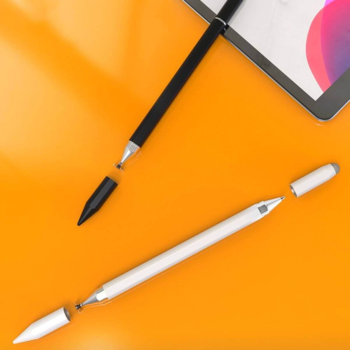 Zwei Stifte, einer schwarz und einer weiß, werden auf einer orangefarbenen Oberfläche neben einem Tablet mit einem farbenfrohen Bildschirm platziert.