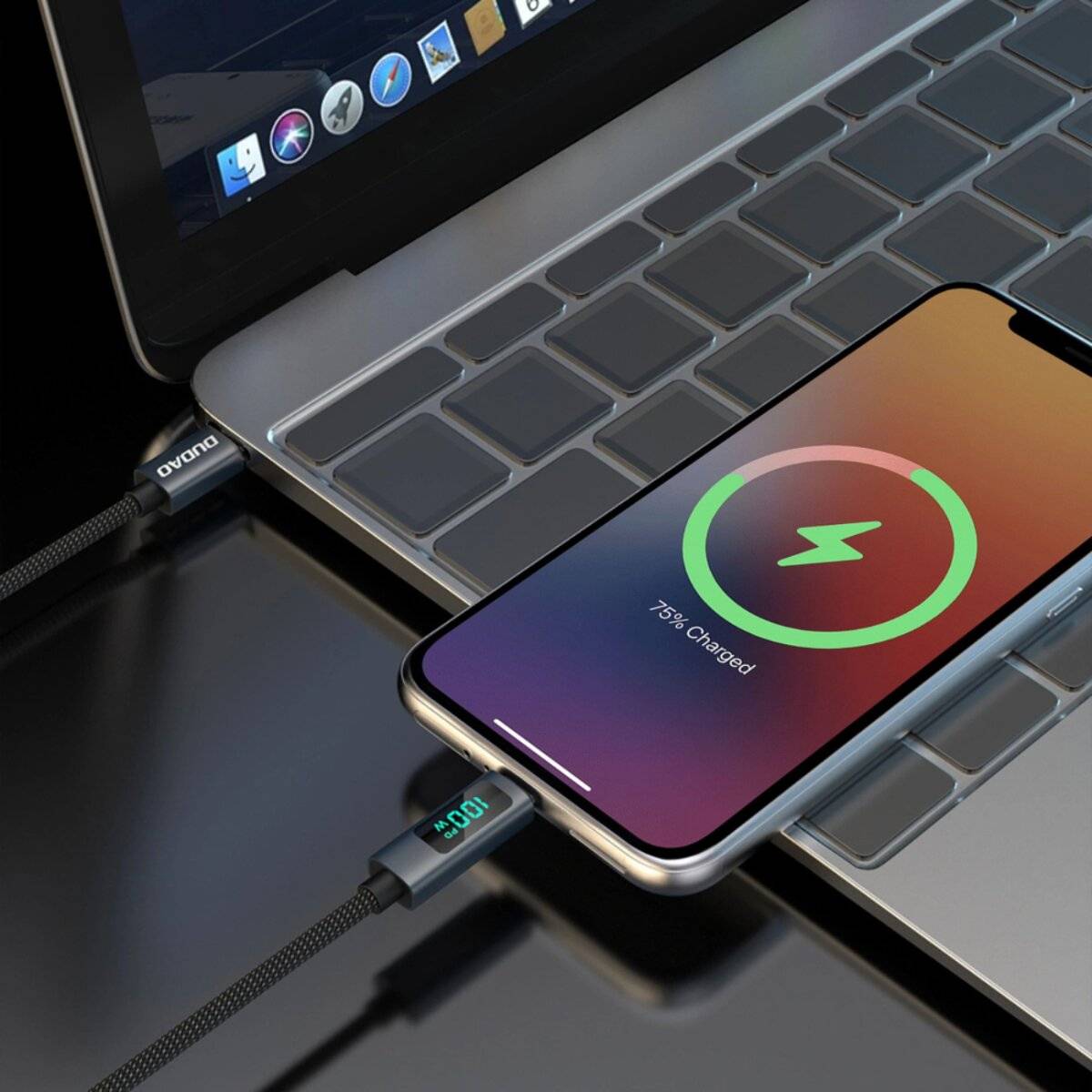 Ein Smartphone mit einem Ladeschirm, auf dem '75% geladen' angezeigt wird, liegt auf einer Laptoptastatur und ist mit einem Ladekabel verbunden, das '100' zeigt.