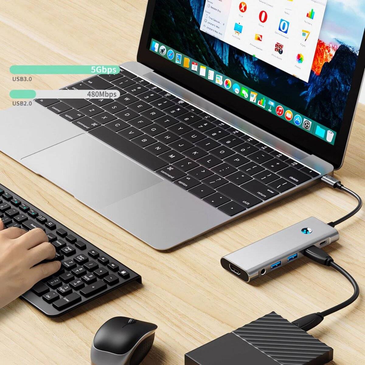 Eine Person nutzt einen Laptop mit angeschlossenem USB-Dock, das Datenübertragungsgeschwindigkeiten anzeigt: „USB 3.0 5Gbps