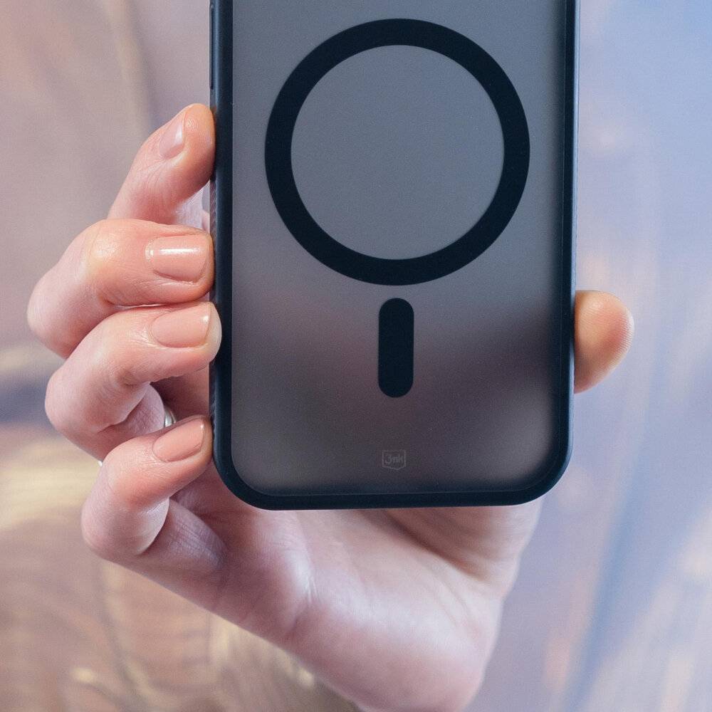 Eine Hand hält ein Smartphone mit einer kreisförmigen Magnetform auf der Rückseite, möglicherweise zum Anbringen von Zubehör oder für kabelloses Laden.