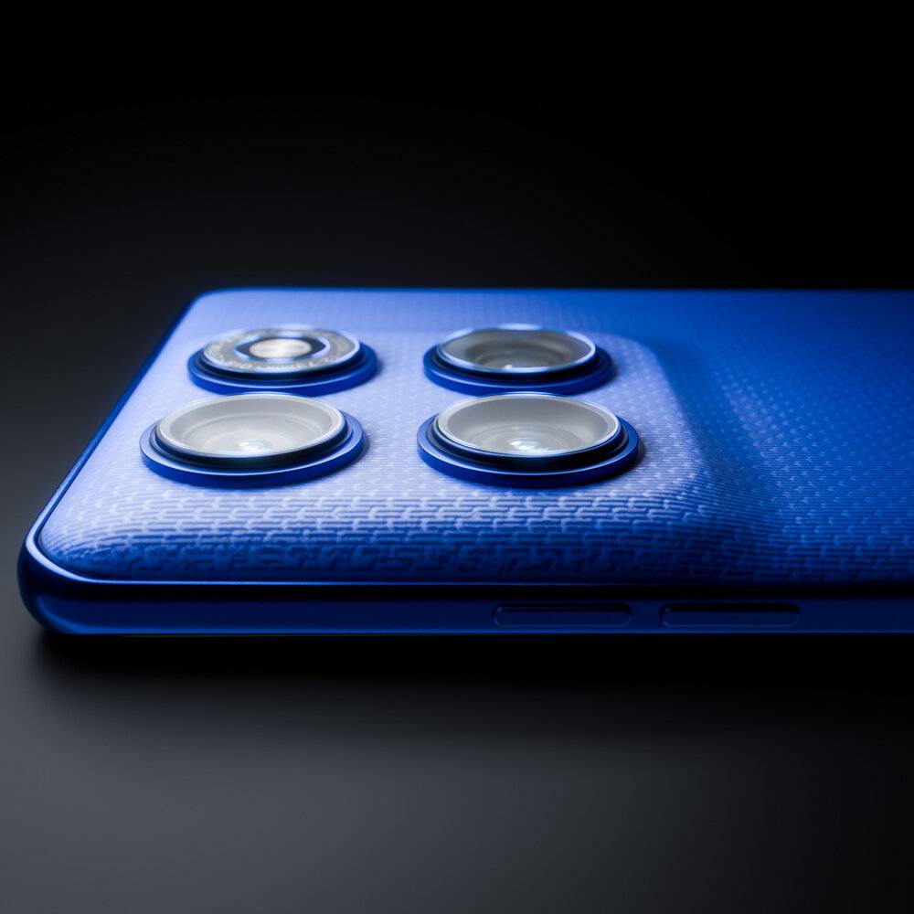 Eine Nahaufnahme eines blauen Smartphones, das sein Quad-Kamera-Setup zeigt, mit Betonung der strukturierten Rückseite und der Kameraobjektive unter weicher Beleuchtung.