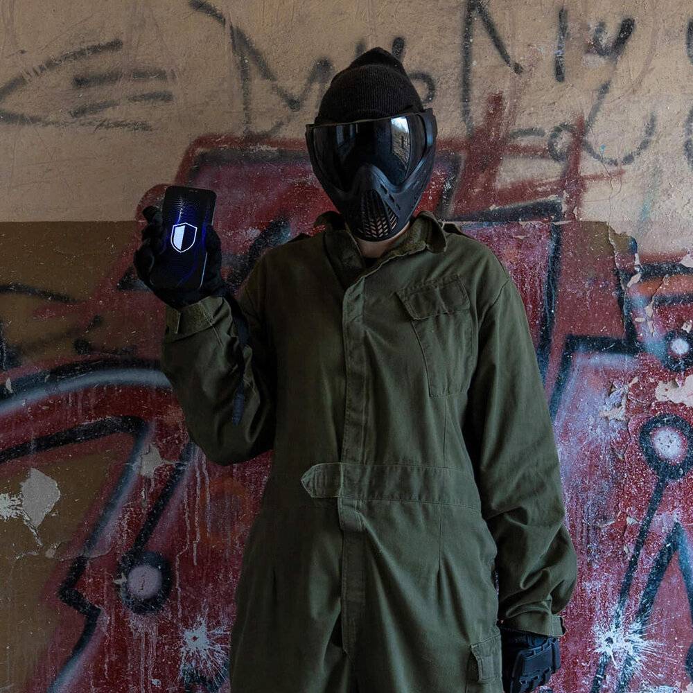 Eine Hand berührt einen Smartphone-Bildschirm, auf dem ein Sicherheitsschild-Symbol auf einem digitalen, blauen Wellenhintergrund angezeigt wird, was Datenschutz andeutet.