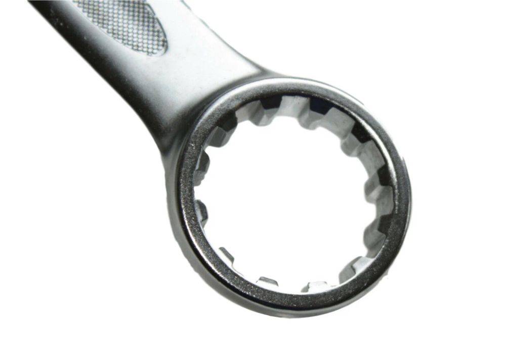 Eine Nahaufnahme eines Metallstecknuss-Kopfes, der seine kreisförmige Öffnung mit mehreren Kerben zeigt, die zum Greifen verschiedener Schraubengrößen ausgelegt ist.