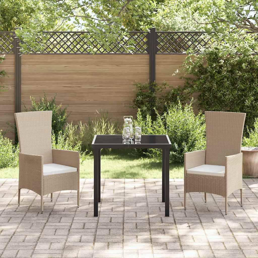Zwei Korbstühle und ein kleiner Tisch mit einem Glaskrug und zwei Gläsern auf einer sonnigen Terrasse, umgeben von Pflanzen und einem Holzzaun.