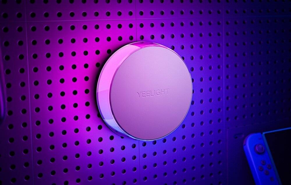 Ein kreisförmiges, violettes an der Wand befestigtes Gerät mit der Aufschrift „YEELIGHT