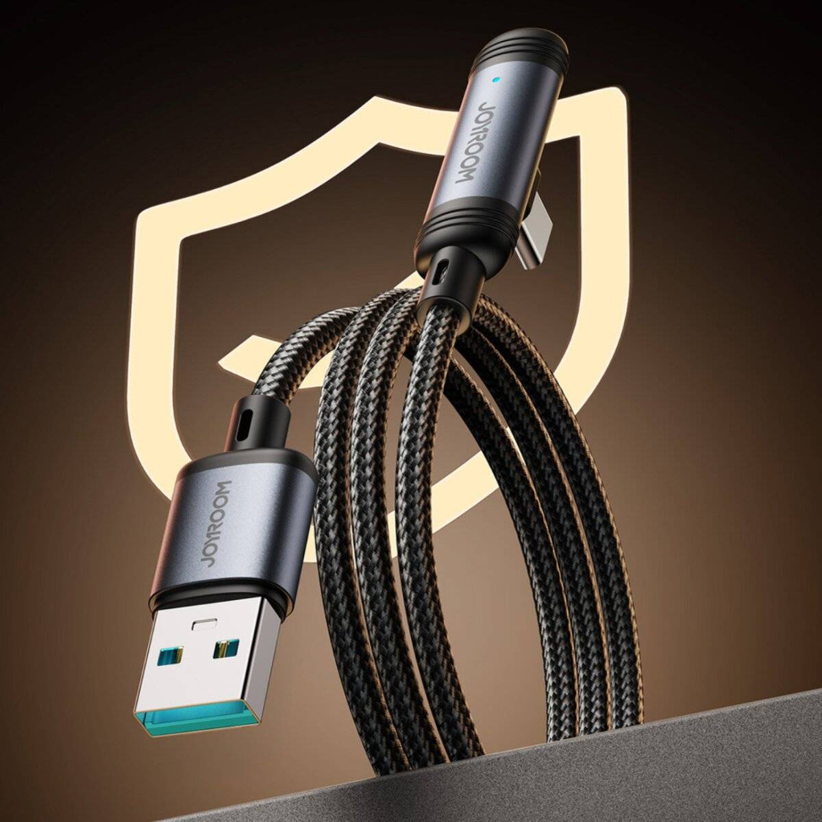 Ein aufgerolltes USB-Kabel mit Metallsteckern und geflochtener Verarbeitung befindet sich vor einem Schildsymbol, was Haltbarkeit und Schutz andeutet.