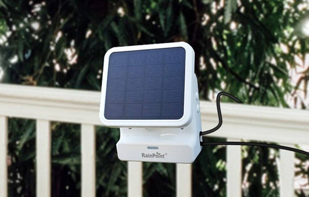 Ein solarbetriebenes Gerät, das auf einem Geländer montiert ist, mit einem sichtbaren Solarpanel und dem Markennamen „RainPoint
