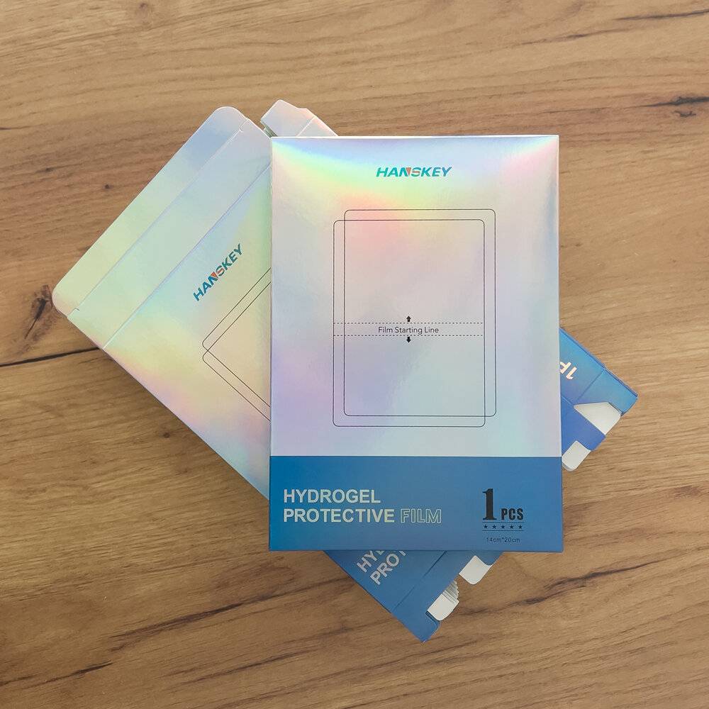 Das Bild zeigt die Verpackung für einen 'HANBEKY' Hydrogel-Schutzfilm mit 1 Stück auf einer Holzoberfläche.