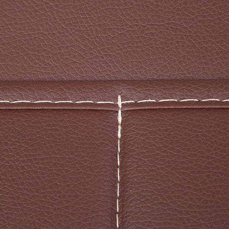 Nahaufnahme von braunem Leder mit weißen Stichlinien, die Rechtecke bilden und Textur sowie Handwerkskunst zur Schau stellen.