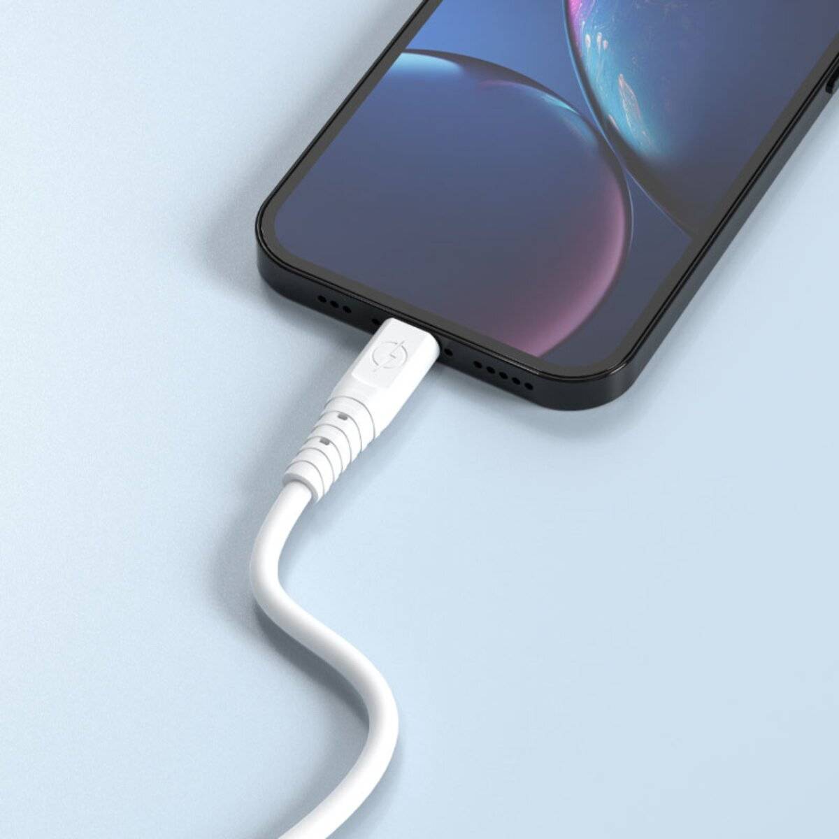 Ein Smartphone mit einem leuchtenden Bildschirm lädt auf einer weißen Oberfläche und ist mit einem weißen Kabel angeschlossen.