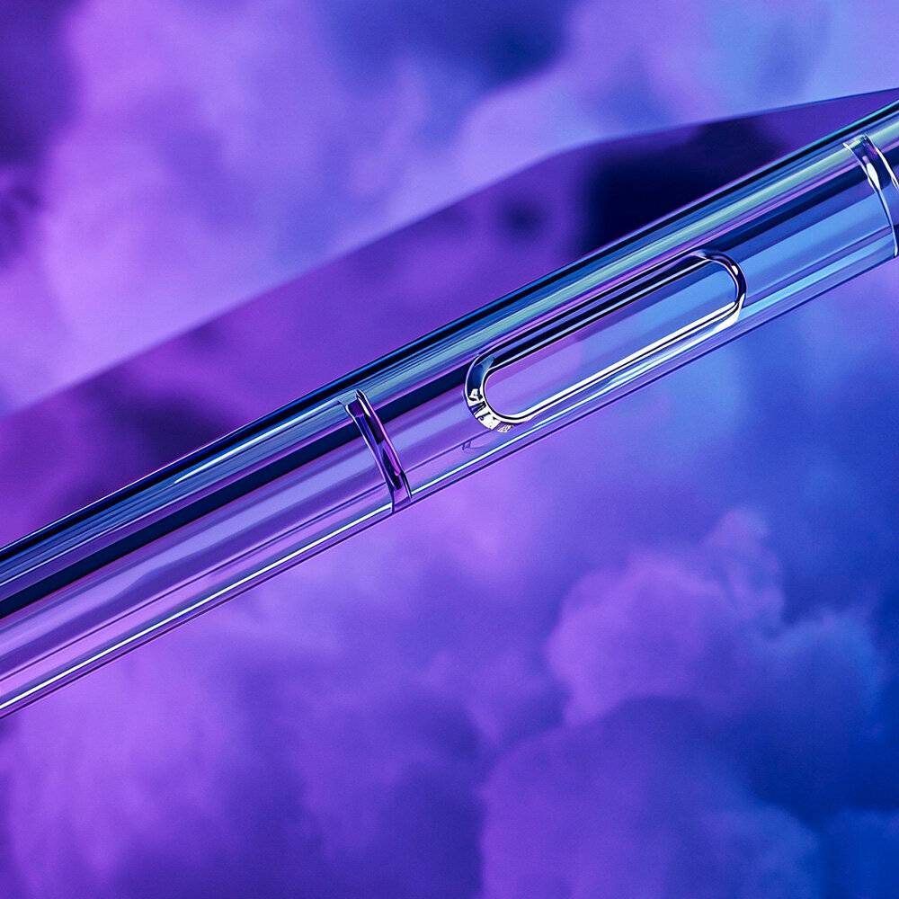 Ein elegantes metallisches Objekt mit einem rechteckigen Knopf, vor einem unscharfen blau- und purpurfarbenen wolkenähnlichen Hintergrund.