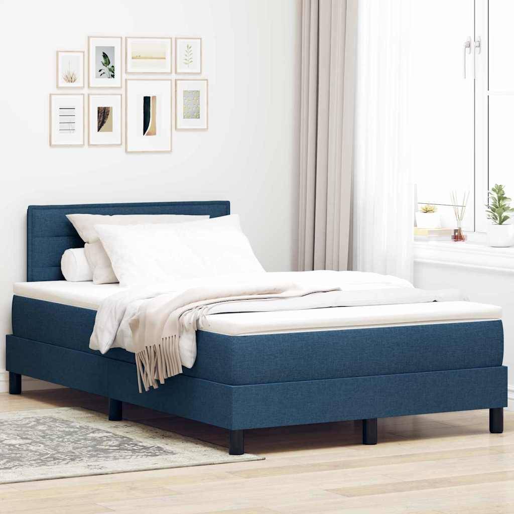 Ein modernes Schlafzimmer mit einem blaugepolsterten Bett mit weißer Bettwäsche, einer Reihe von gerahmten Kunstdrucken an der Wand und einem nahegelegenen Fenster mit Vorhängen.