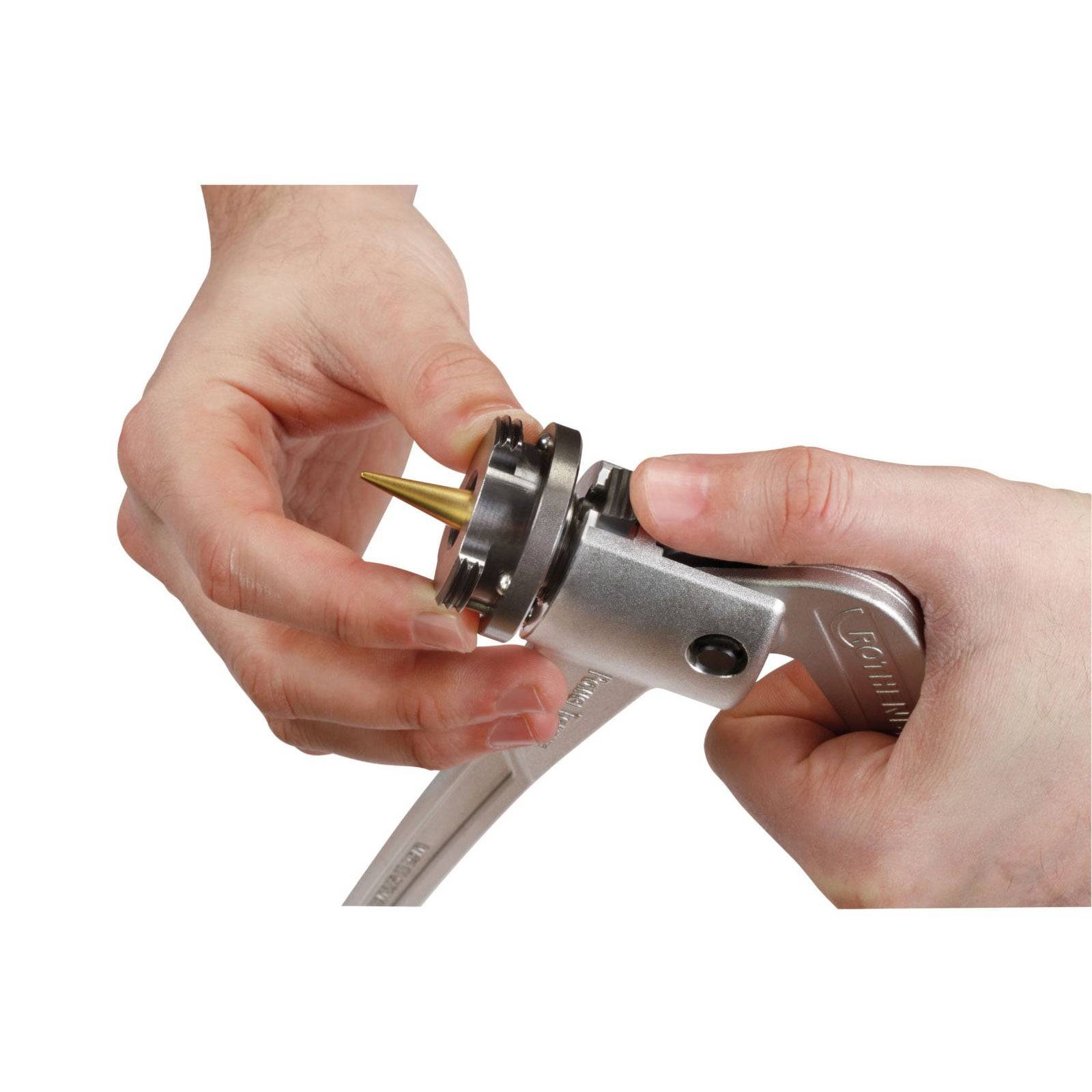 Zwei Hände bauen ein metallisches Handwerkzeug mit einer spitzen Spitze zusammen; eine Hand hält das Werkzeug, während die andere die Komponenten justiert.