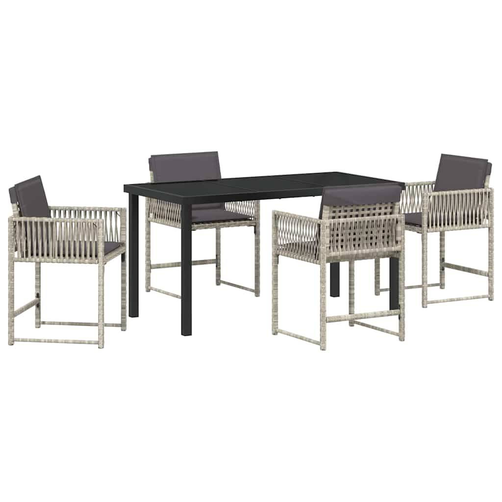 Outdoor-Essgruppe mit einem schwarzen rechteckigen Tisch und vier Rattanstühlen mit grauen Kissen, arrangiert für eine Garten- oder Terrassensituation.