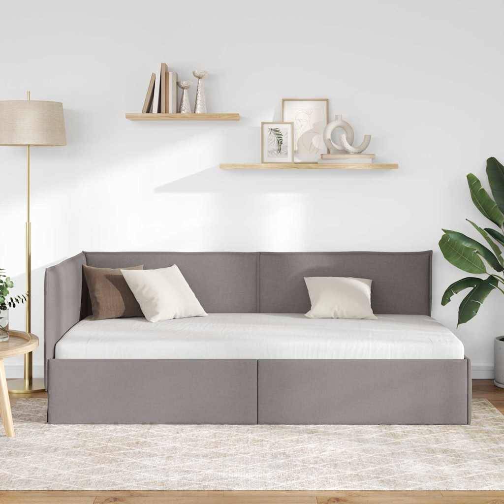 Ein modernes Wohnzimmer zeigt ein graues Tagesbett mit weißen und braunen Kissen, zwei schwebende Holzregale mit Dekorationselementen, eine große Pflanze und eine stehende Lampe.