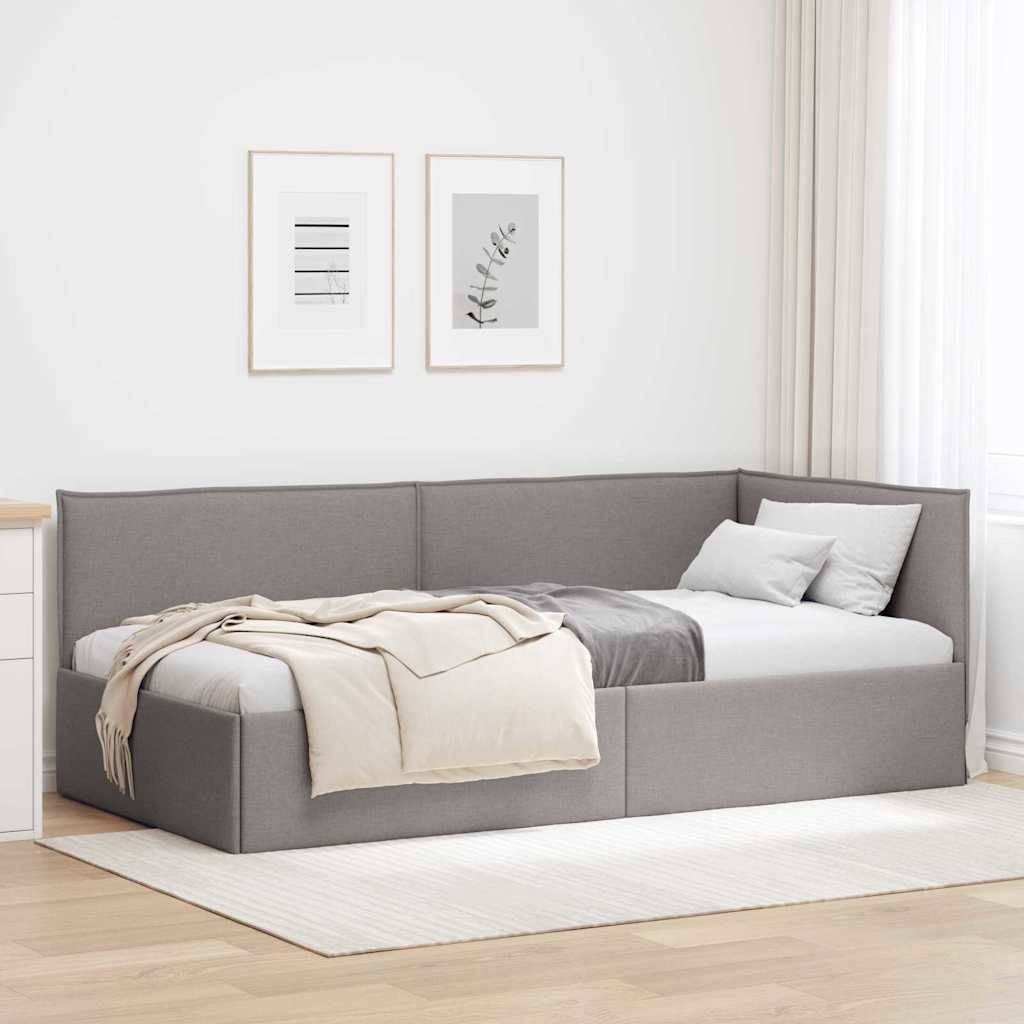 Das Bild zeigt eine moderne Schlafzimmerecke mit einer grau gepolsterten Tagliege, die mit beige- und weißfarbenen Decken und Kissen ausgestattet ist, zwei gerahmten Kunstdrucken und einem neutralen Teppich.