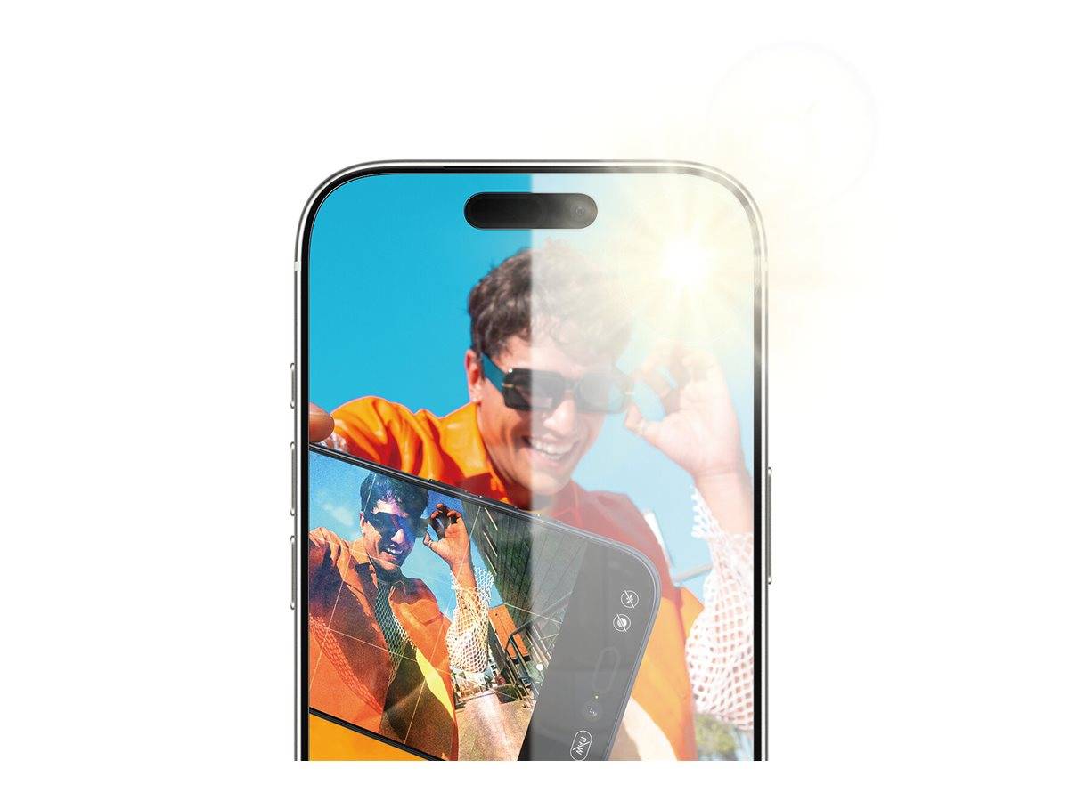 Eine Person mit Sonnenbrille und orangefarbenem Shirt spiegelt sich in einem Smartphone-Bildschirm wider, während sie ihre Sonnenbrille vor einem klaren blauen Himmel zurechtrückt.