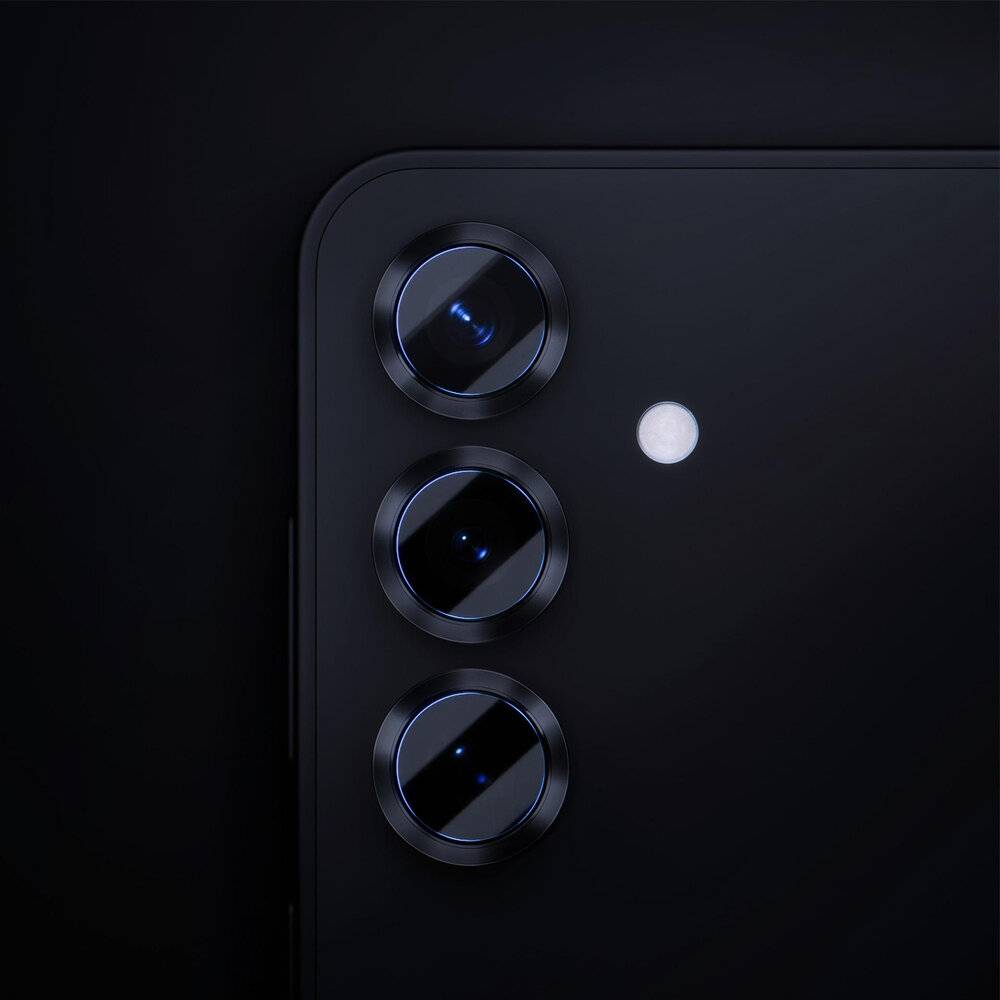 Eine Nahaufnahme des rückwärtigen Triple-Kamera-Systems eines Smartphones bei schlechten Lichtverhältnissen, wobei die Linsen und das Blitzlicht vor einem dunklen Hintergrund hervorgehoben werden.