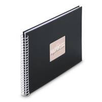 Ein schwarzes spiralgebundenes Notizbuch mit einem metallischen Quadrat in der Mitte der Vorderseite.