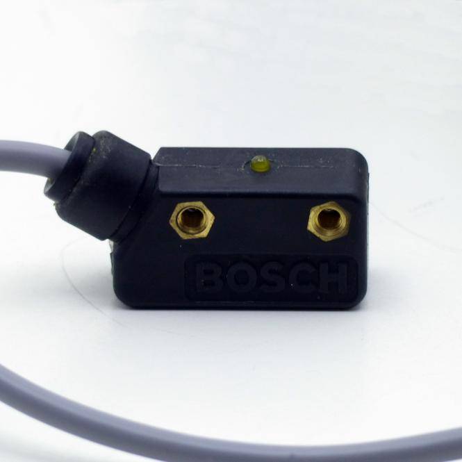 Nahaufnahme eines schwarzen elektronischen Sensorsmoduls von Bosch mit zwei Messing-Schraubklemmen und angekoppeltem grauem Kabel auf weißem Hintergrund.