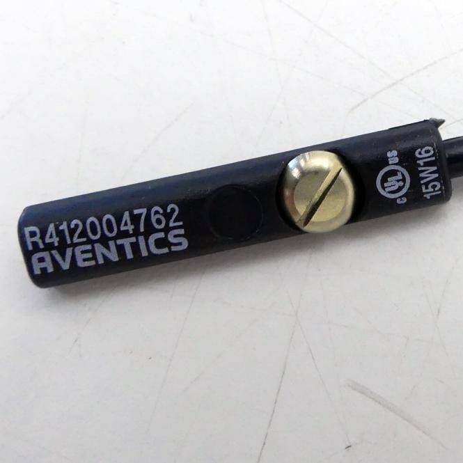 Schwarze Aventics-Elektrokomponente mit einer Messingschlitzschraube, gekennzeichnet mit 'R412004762' und '15W16', dargestellt auf einer weißen Oberfläche.