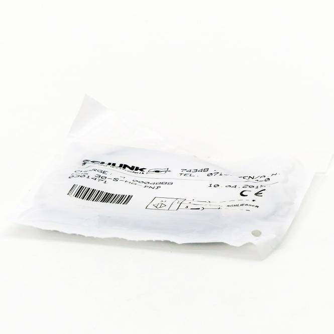 Ein kleines weißes Etikett für Elektronik oder Versandschein mit Barcodes und gedruckten Produktdetails auf einem schlichten weißen Hintergrund.