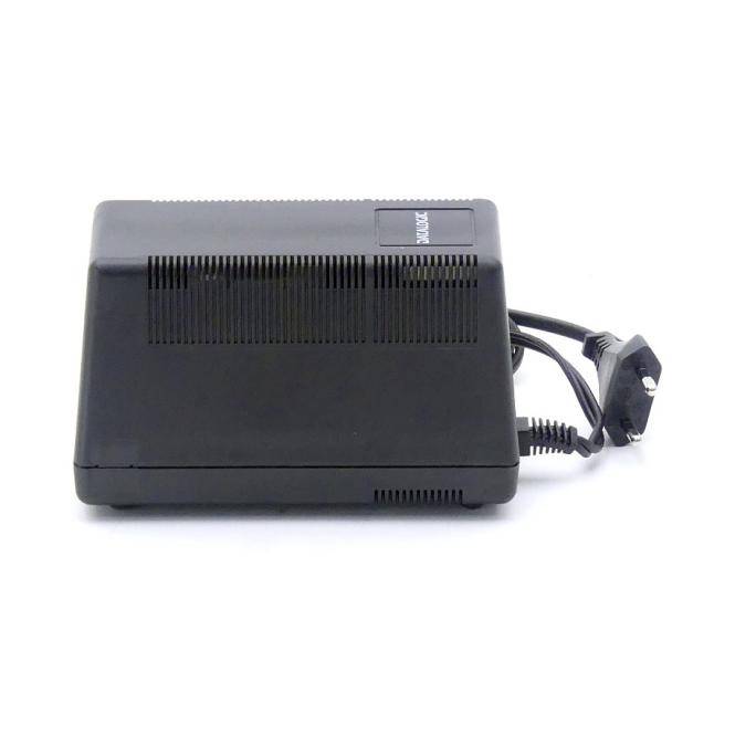 Schwarzes rechteckiges elektronisches Gerät mit Belüftungsschlitzen und angeschlossenem Stromkabel und Stecker, dargestellt auf weißem Hintergrund.