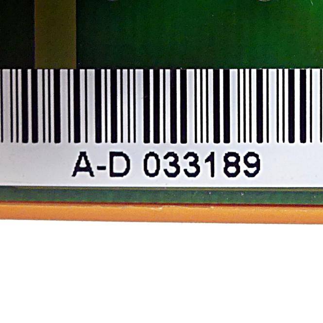 Nahaufnahme eines Barcode-Etiketts mit dem Code 'A-D 033189' auf einer grünen Leiterplatte oder elektronischen Komponente.