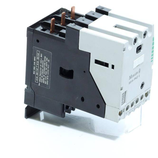 Nahaufnahme eines elektrischen Schützkontaktors mit schwarzweißem Gehäuse, Kupferanschlüssen und Montagebasis auf weißem Hintergrund.