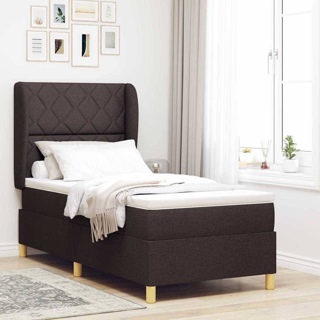 Ein ordentlich gemachtes Bett mit dunklem Rahmen und heller Bettwäsche in einem hellen Raum mit weißen Wänden und Fenster, dekoriert mit gerahmten Bildern darüber.