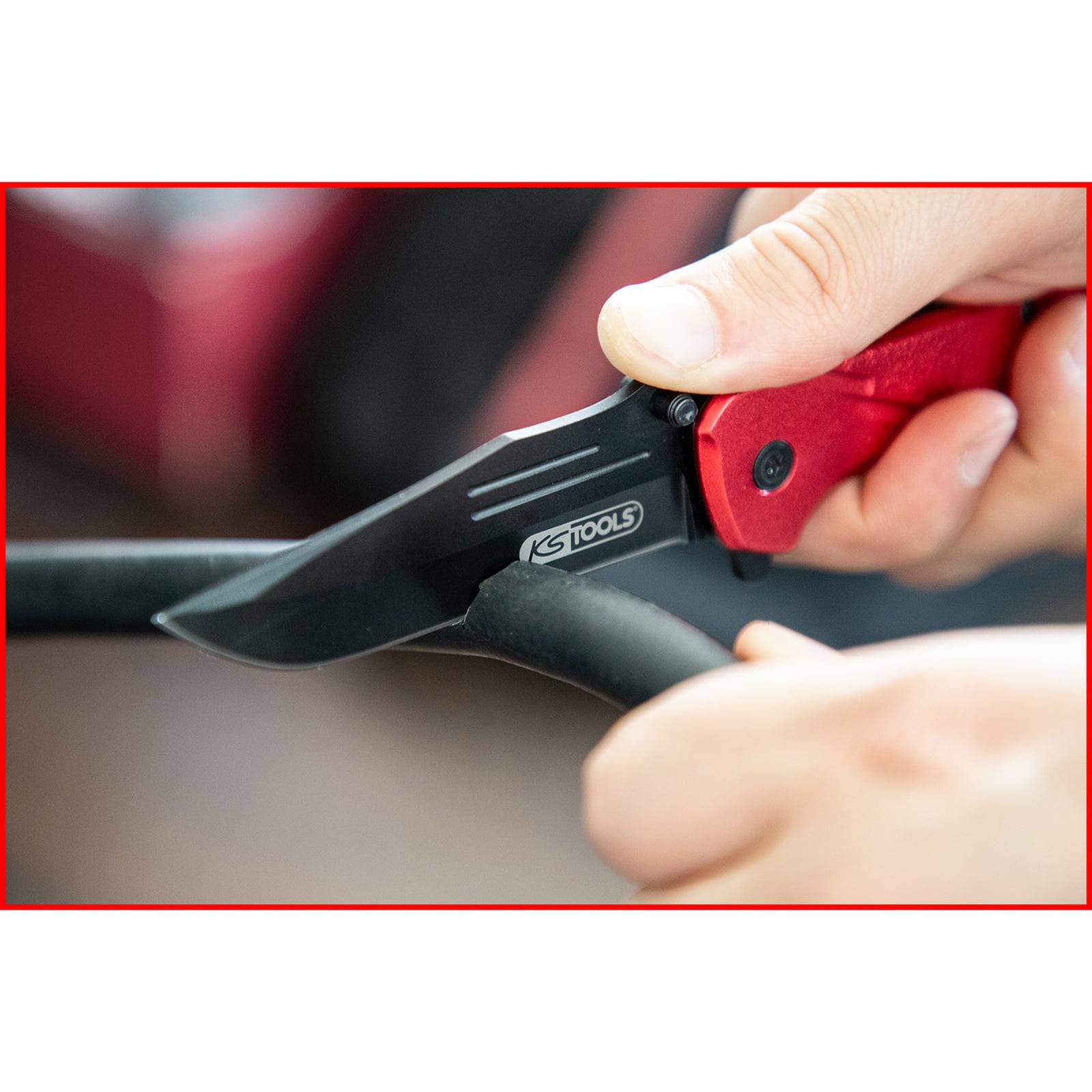 Eine Person verwendet ein Messer mit rotem Griff der Marke 