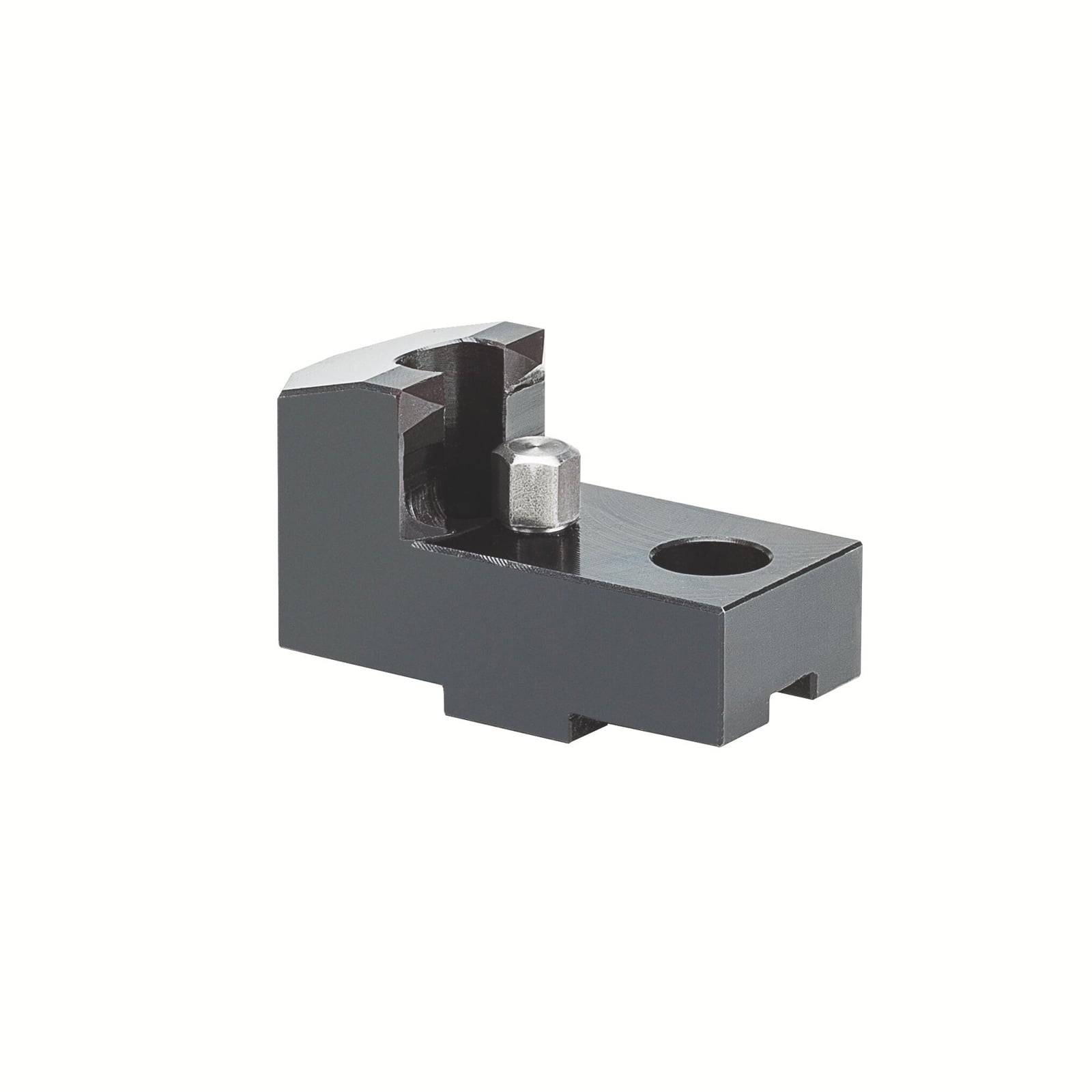 Ein schwarzer Metallblock mit einem runden Stift und einem Loch, wahrscheinlich ein mechanisches Bauteil oder Werkzeugteil, auf weißem Hintergrund.