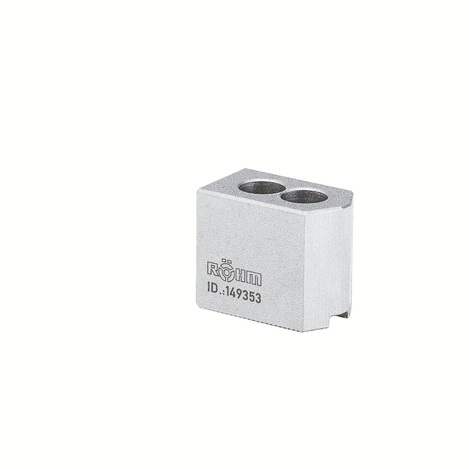 Ein Metallblock mit zwei kreisförmigen Löchern und der Aufschrift 