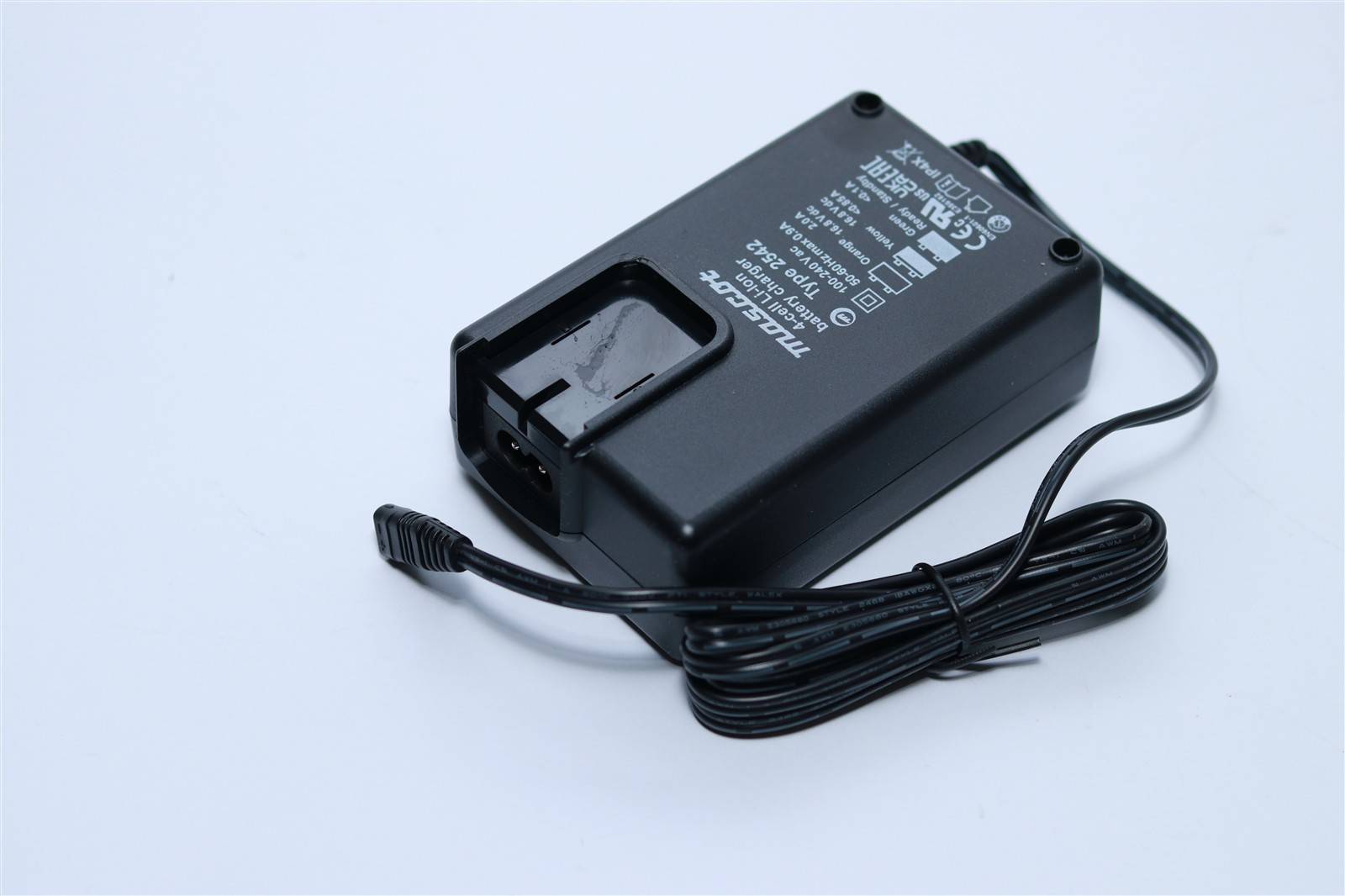 Ein schwarzer Stromadapter mit einem aufgewickelten Kabel, auf dessen Oberfläche gekennzeichnete elektrische Spezifikationen angebracht sind.