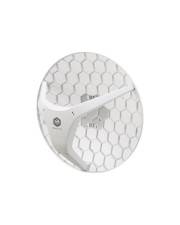 Weißes, rundes Mesh-Funkgerät, das gegen eine Oberfläche mit Sechskantmuster montiert ist, wahrscheinlich ein WLAN-Zugriffspunkt oder eine Antenne.