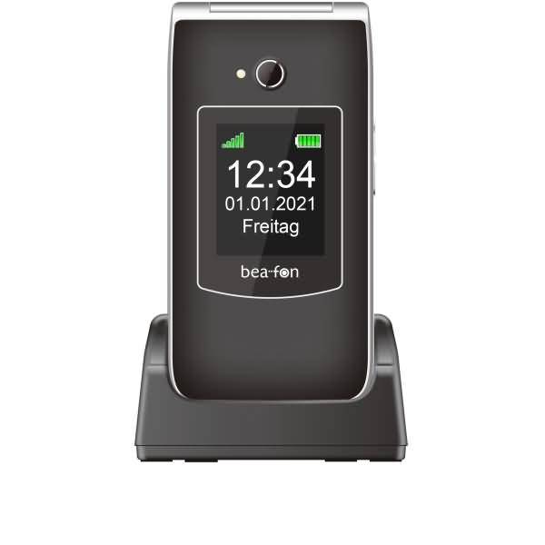 Faltbares Beafon-Mobiltelefon aufrecht in einer Ladestation angezeigt, auf dem Bildschirm werden 12:34, Datum 01.01.2021 und 