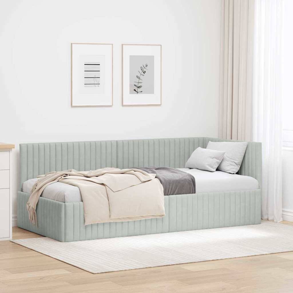 Ein minimalistisches Schlafzimmer mit einem Bett in hellem Salbeigrün an einer Wand, geschmückt mit neutralfarbenen Decken und Kissen. Zwei gerahmte Kunstwerke hängen darüber.