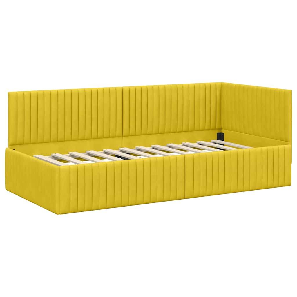 Gelbes, gepolstertes Tagesbett mit vertikaler Knopfheftung und Lamellenbasis, von einem Winkel aus fotografiert, das sein modernes Design und seine lebendige Farbe hervorhebt.