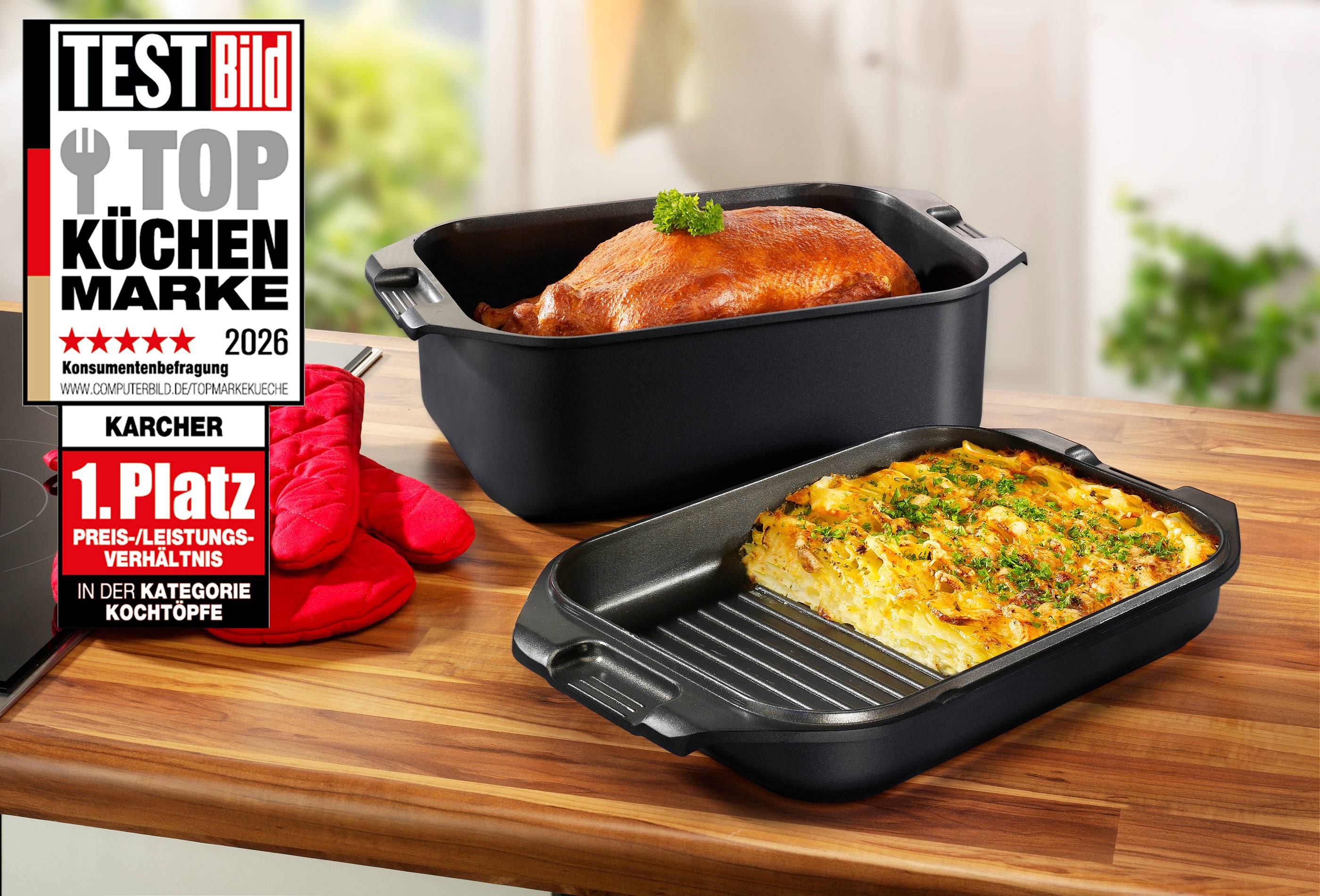 Zwei schwarze Bräter auf einer Holzoberfläche; einer mit einem gebratenen Hähnchen, der andere mit Kartoffelgratin. Ein rotes Ofenhandschuh daneben.