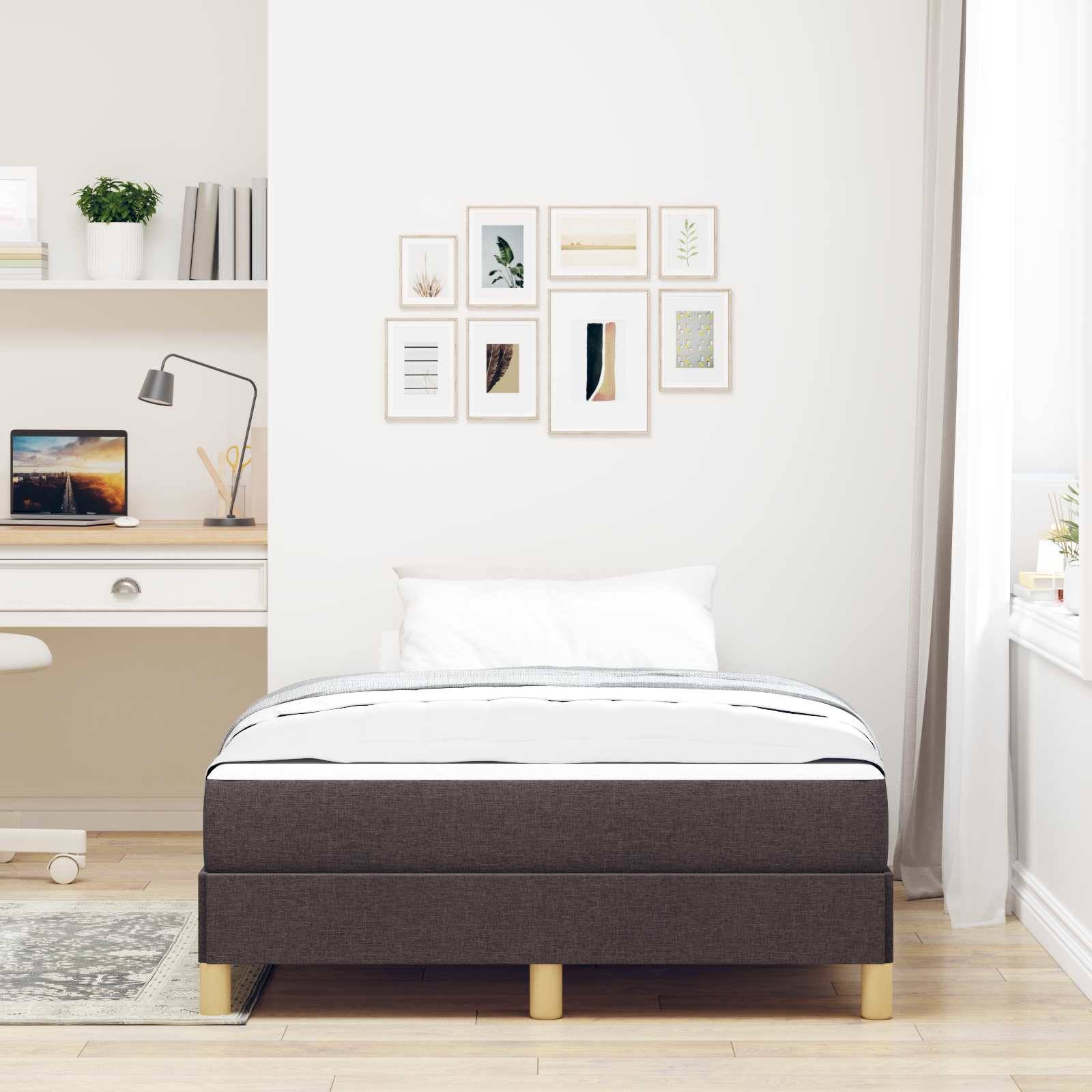Ein modernes Schlafzimmer mit einem ordentlich gemachten Bett in Weiß- und Grautönen. Ein Schreibtisch mit einem Computer und Regale mit Dekoration sind sichtbar.