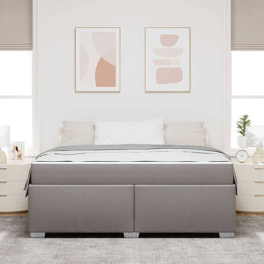 Minimales weißes Schlafzimmer mit einem grau gepolsterten Bett, weißen Nachttischen, abstrakter Wandkunst und einem hellen Teppich.