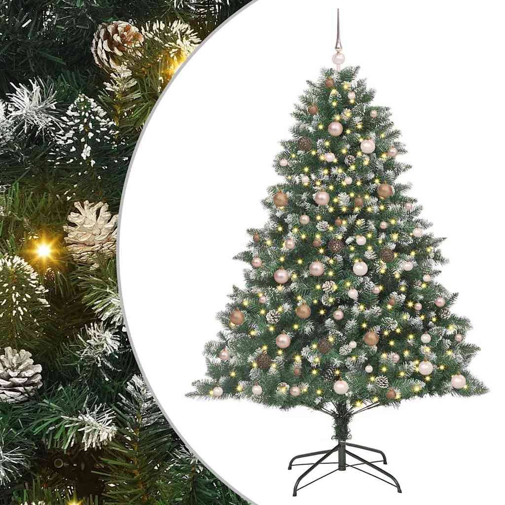 Ein geschmückter künstlicher Weihnachtsbaum mit Lichtern, Christbaumkugeln und Tannenzapfen. Er steht auf einem Metallständer vor einem geteilten Hintergrund.